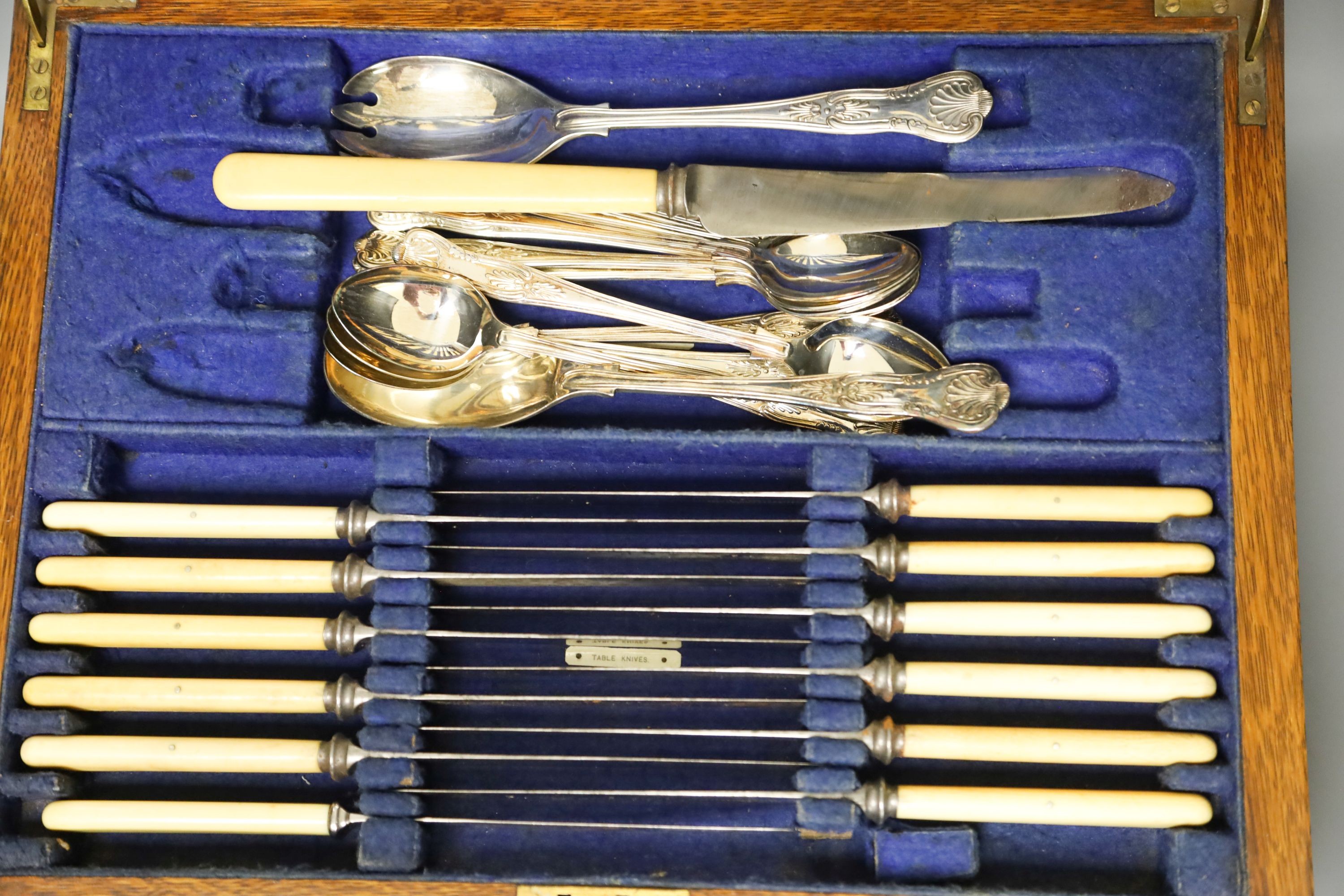 An Edwardian oak cased canteen of plated Kings pattern cutlery